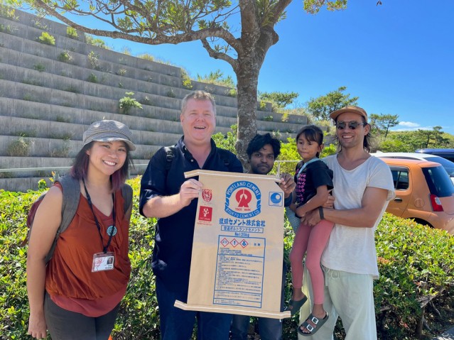 People holding a bag of Ryukyu Cement with the Coral Project's logo mark