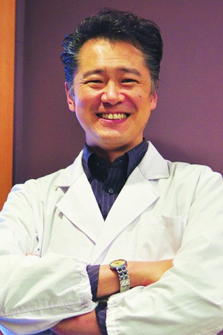 A man smiling in white coat
