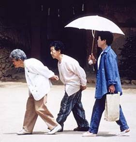 Three old women walking, the first two crouched over