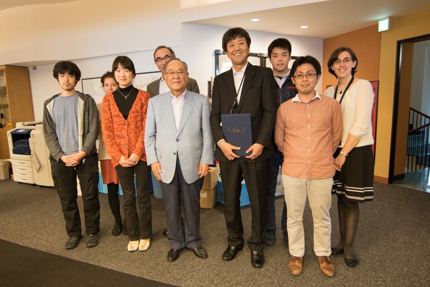 Mr. Fujio Mitarai, chiarman and chief executive of Canon Inc. (middle), and the members of the OIST Marine Biophysics Unit. 