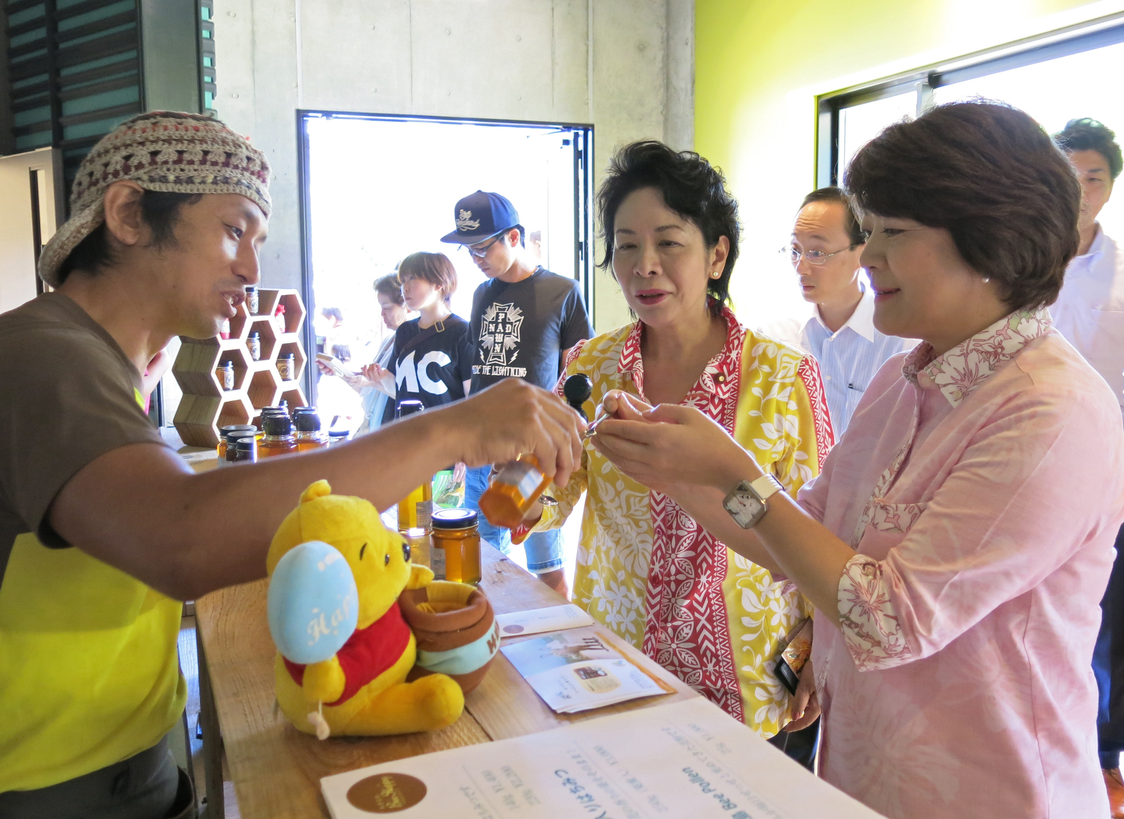 Minister Aiko Shimajiri and lawmaker Natsumi Higa tasting local honey