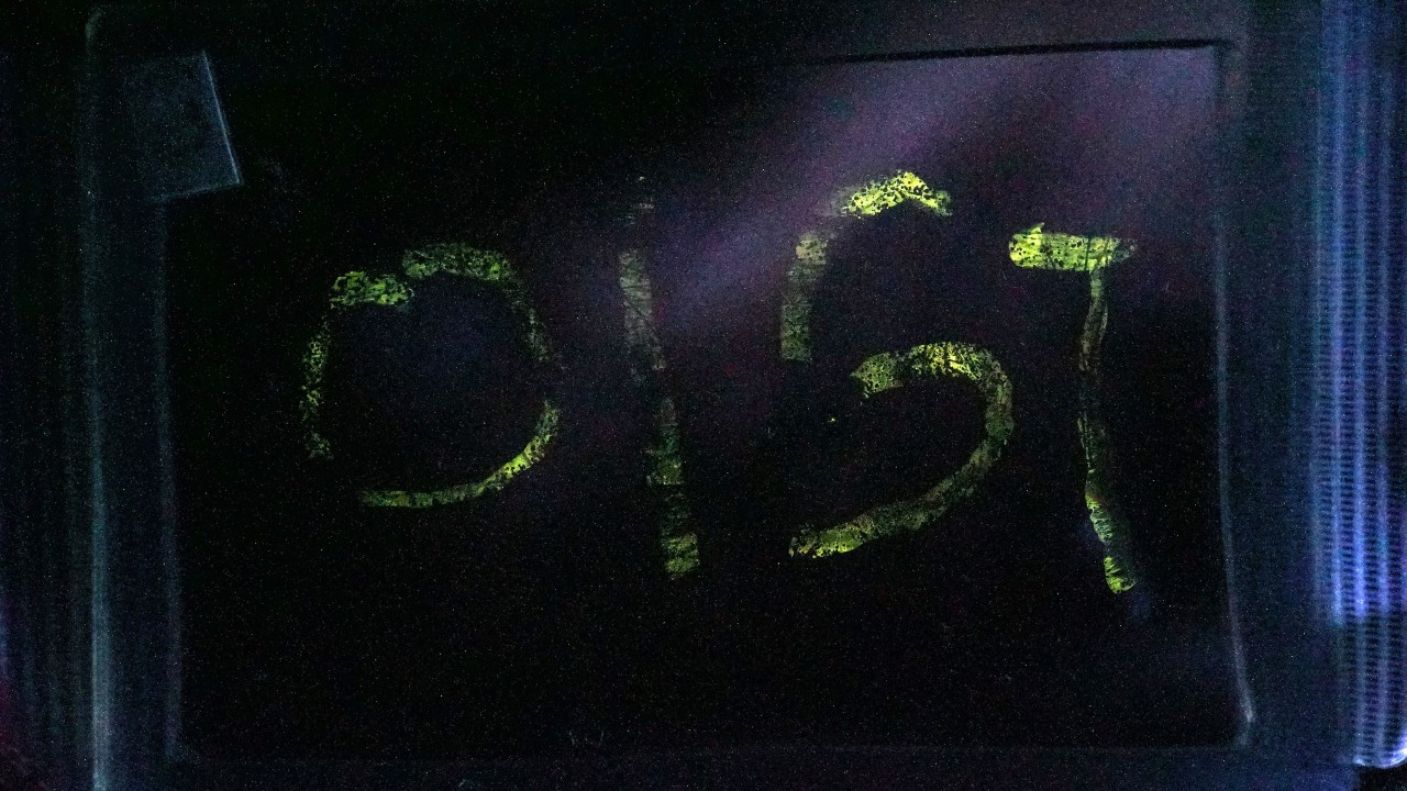 The letters OIST are spelled out in glowing lights thanks to mechanoluminescence from amorphous thin films. This is a photo taken with long exposure.
