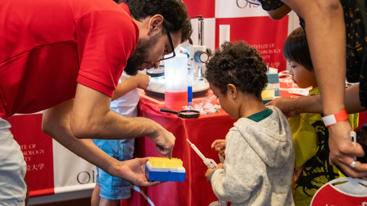 a researcher showing research equipment to children