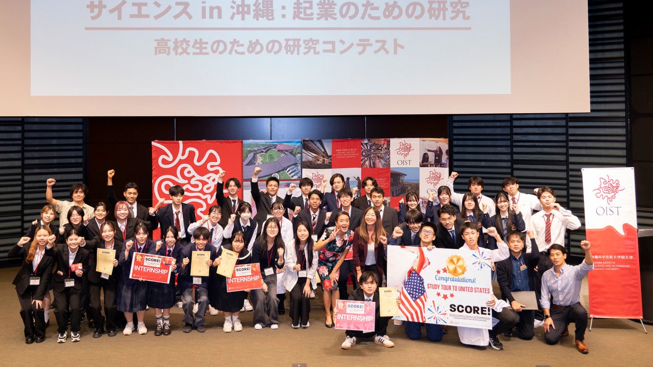 students on the stage pausing for a photo