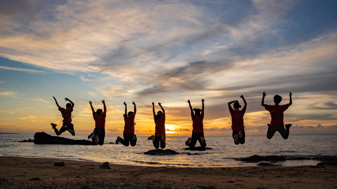 Silhouette of people jumping on the beach