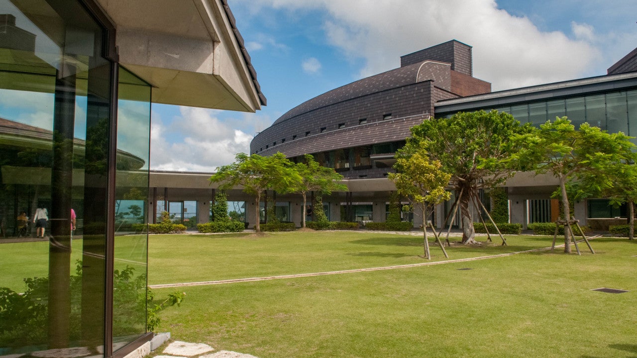 OIST buildings surrounded by a grassy lawn