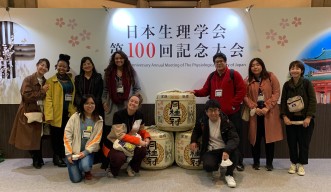 unit members in front of a panel of The Physiological Society of Japan’s 100th Anniversary