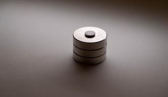 黒いグラファイトの円盤が、円形の磁石3個の上で浮かんでいる様子。