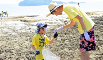 Child and teacher looking at animals at low tide