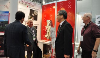 BioJapan2012のOISTブースで訪問者に挨拶をするパトリック・ヴィンセント副学長（財務・人事担当）とスコグラント教授