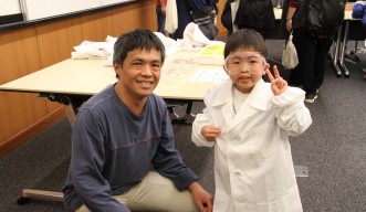 Children put on lab coats and eye protection to look like scientists