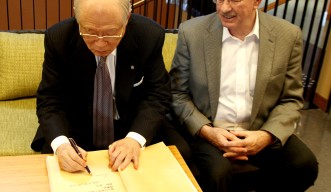 OISTのご芳名帳にサインをする理化学研究所理事長でノーベル賞受賞者の野依良治博士