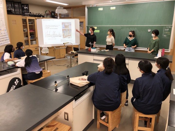 Scientists giving presentation to junior high school students in a classroom
