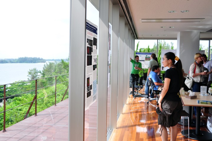 Researcher looking at poster session with ocean visible in background