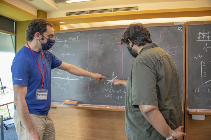 Dr. Danny Bulmash, Theoretical Sciences Visiting program’s visitor (left) discusses ideas on magnetic phases with Dr. Geet Rakala (right), a postdoctoral scholar in the Theory of Quantum Matter Unit.