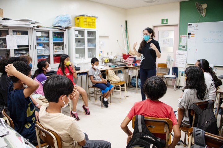 elementary school children listening to an adult speaker in the classroom
