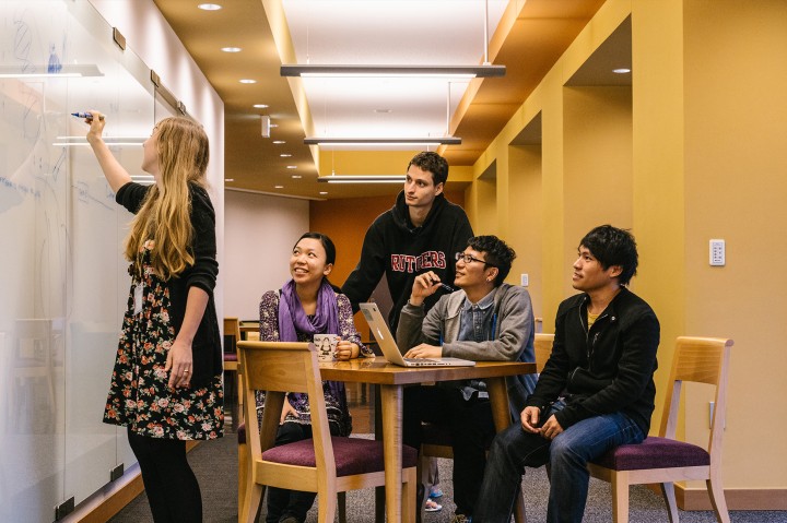 students sitting around the table in front of the white board