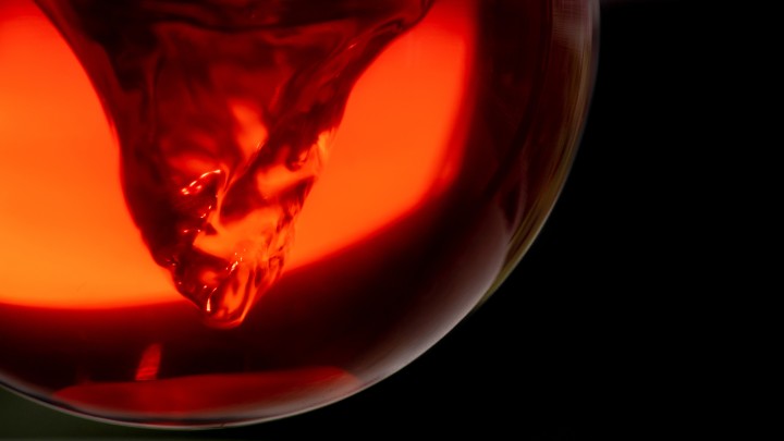 Vortex of red liquid spinning in beaker.