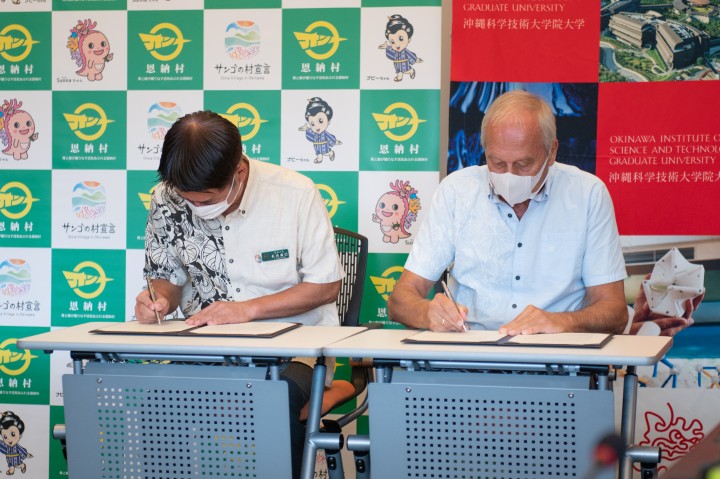 Onna Village Mayor Nagahama (left) and OIST President Gruss (right) sign the agreement