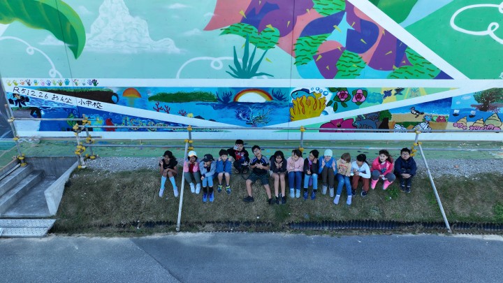 アートの壁の前で集まるおんな小学校の児童