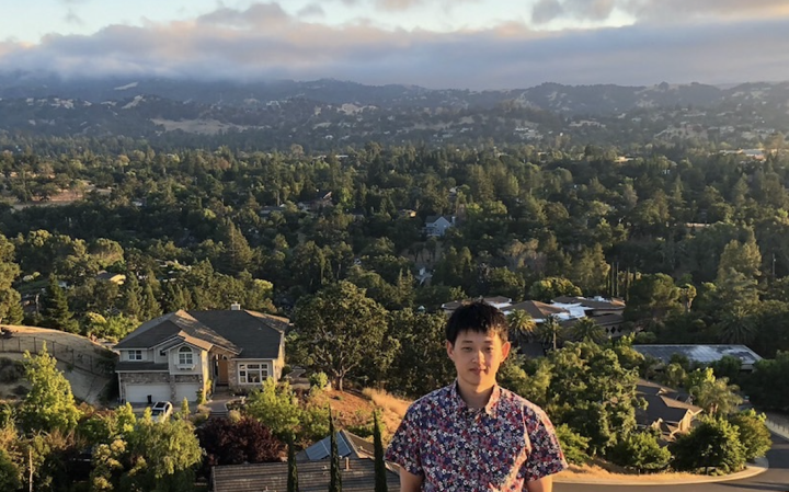 Photo of Jun with mountains in the background