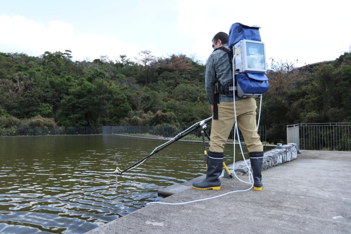 User in field deploying eDNA sampler