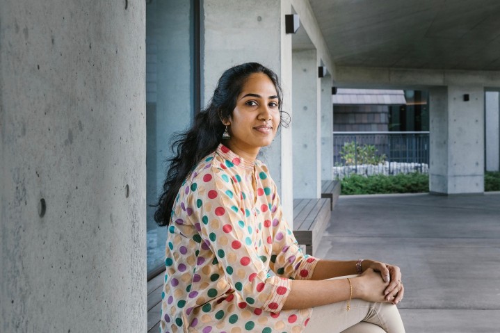 Women sitting with body facing right while looking at camera