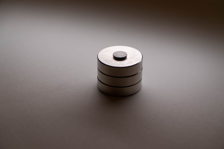 黒いグラファイトの円盤が、円形の磁石3個の上で浮かんでいる様子。