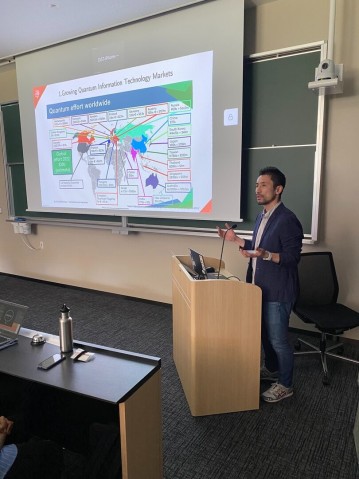 A speaker presenting in front of a screen