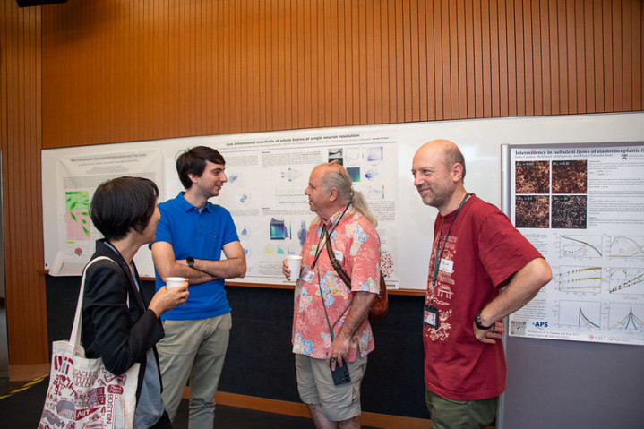 Four researchers discussing in front of research posters