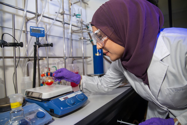 A researcher working on a lab equipment
