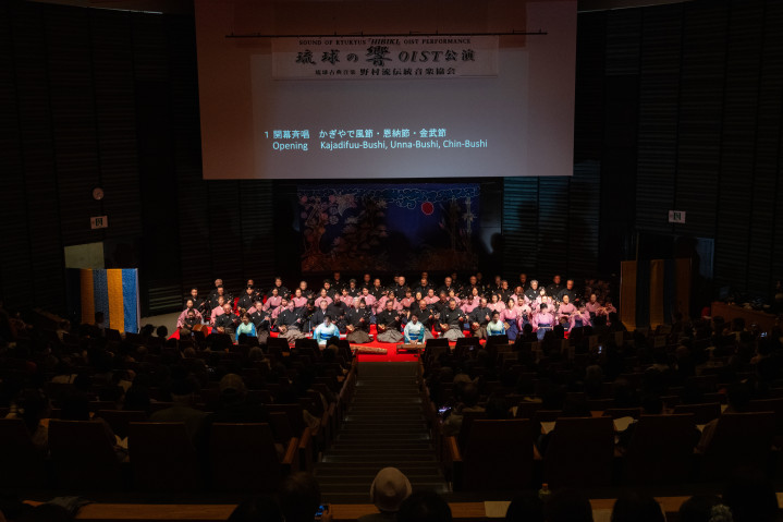 An opening chorus featuring all members of the Traditional Music Association of the Nomura School of Ryukyuan Classical Music. Six OIST staff members who study the sanshin at OIST also took part in the performance. 