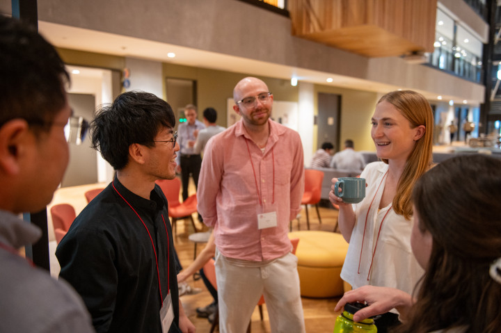 Photograph of a group of people conversing in an academic setting.