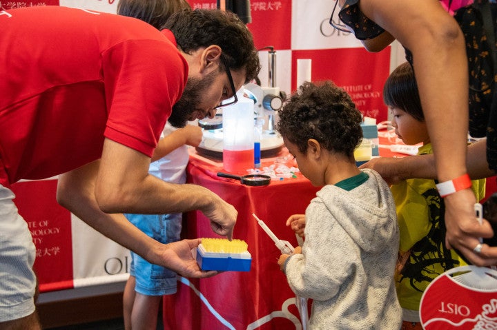 a researcher showing research equipment to children