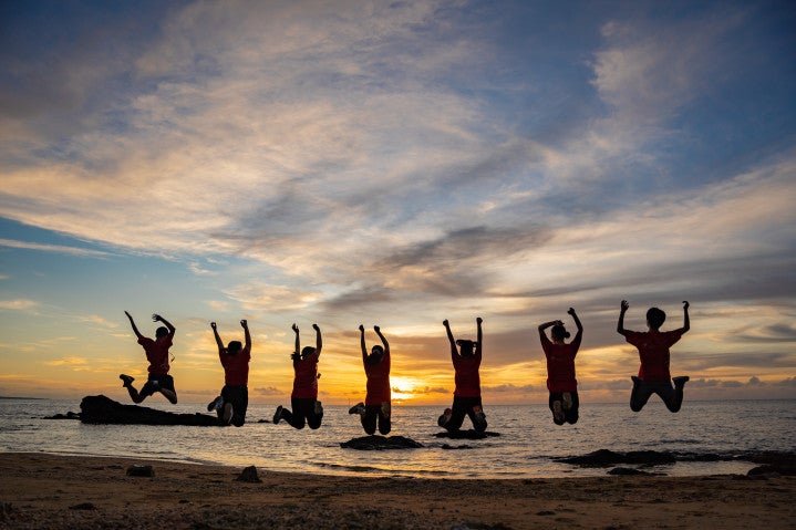 Silhouette of people jumping on the beach