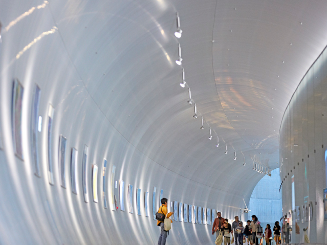 people walking in a white tunnel 