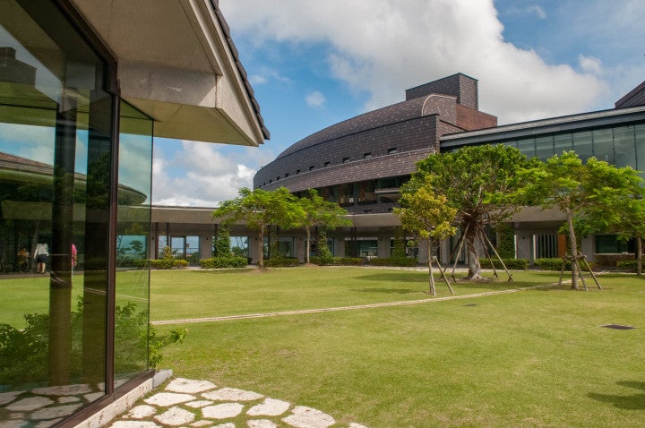 OIST buildings surrounded by a grassy lawn