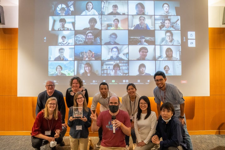 a group of people in front of a screen showing other people's faces