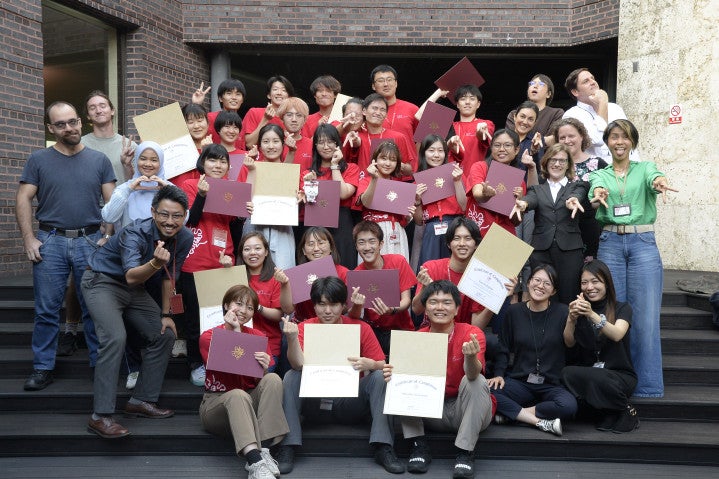a group of students in red shirts holding certificates