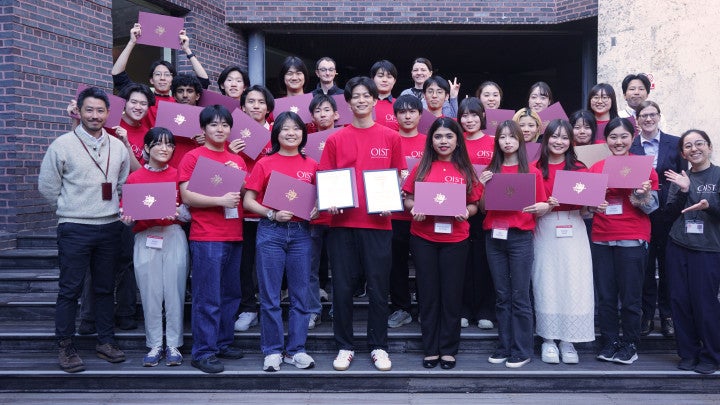 a group of students in red shirts holding certificate