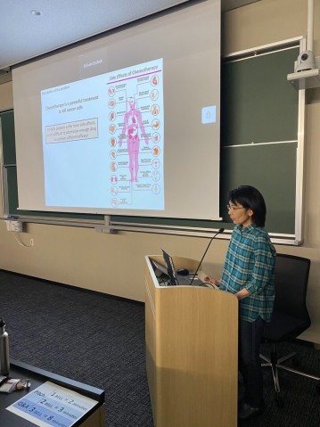 A speaker presenting in front of a screen