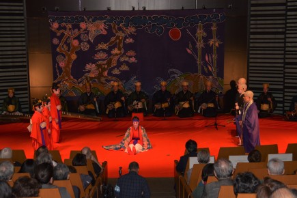 red stage with dancer sitting in center