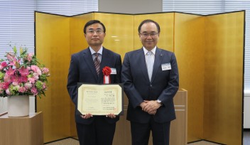 OIST Professor, Dr. Yabing Qi (left) displays the Kao Science Prize certificate, along with Yoshihiro Hasebe, President of The Kao Foundation for Arts and Sciences (right). 