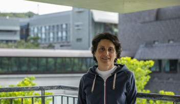 Matin Miryeganeh on the OIST campus with out-of-focus lab buildings behind her
