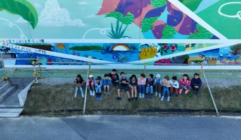 アートの壁の前で集まるおんな小学校の児童