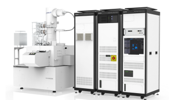 Apparatus which ressembles a column (electron beam housing), with fully enclosed sample area. Right side: control hardware rack (three units side by side).