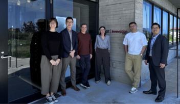 Six people stood outside a building and a sign saying ‘OIST Innovation Core 2’.