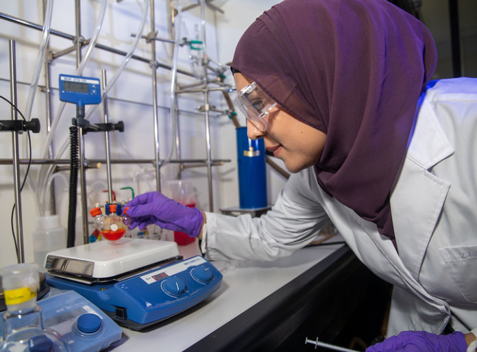 A researcher working on a lab equipment