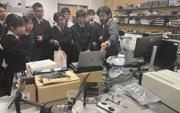 Soumen showing visiting students something on a PC.