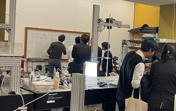 Jack writing on a white board in front of students.